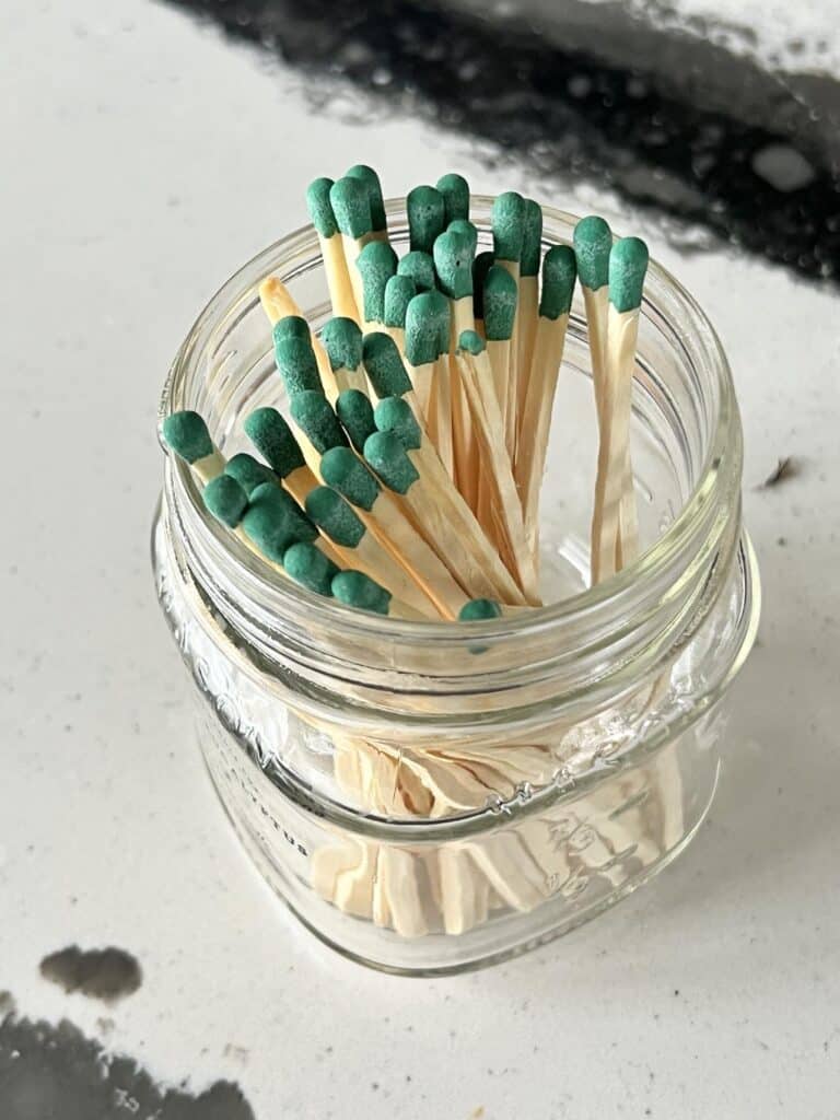A match striker jar holding turquoise safety matches.