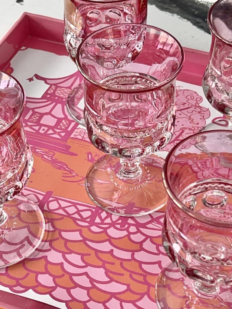 A tray full of pink wine glasses.