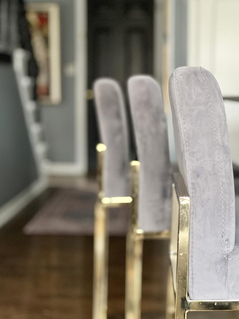 Three bar stools sitting in front of the kitchen island.