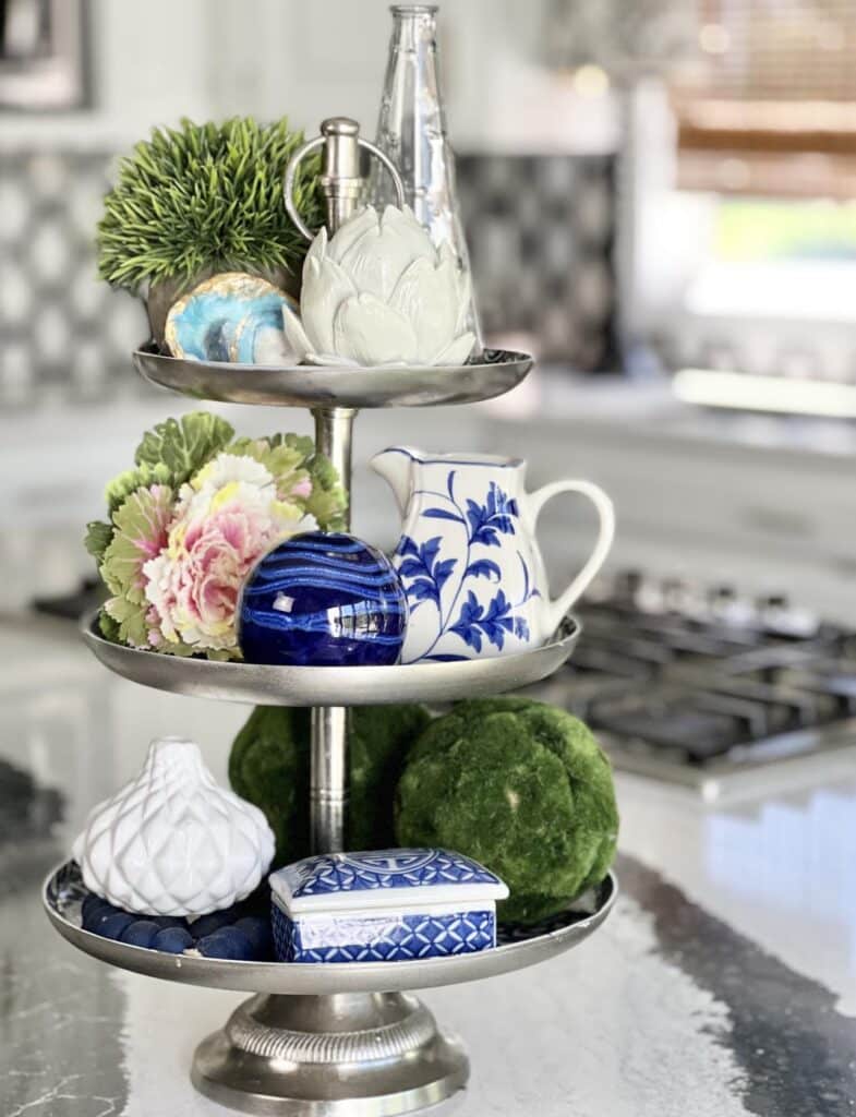 Displaying decorative accents on a tiered tray for how to decorate a kitchen island. 