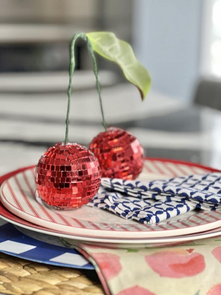 DIY Disco Ball Cherries sitting on top of a summertime place setting.