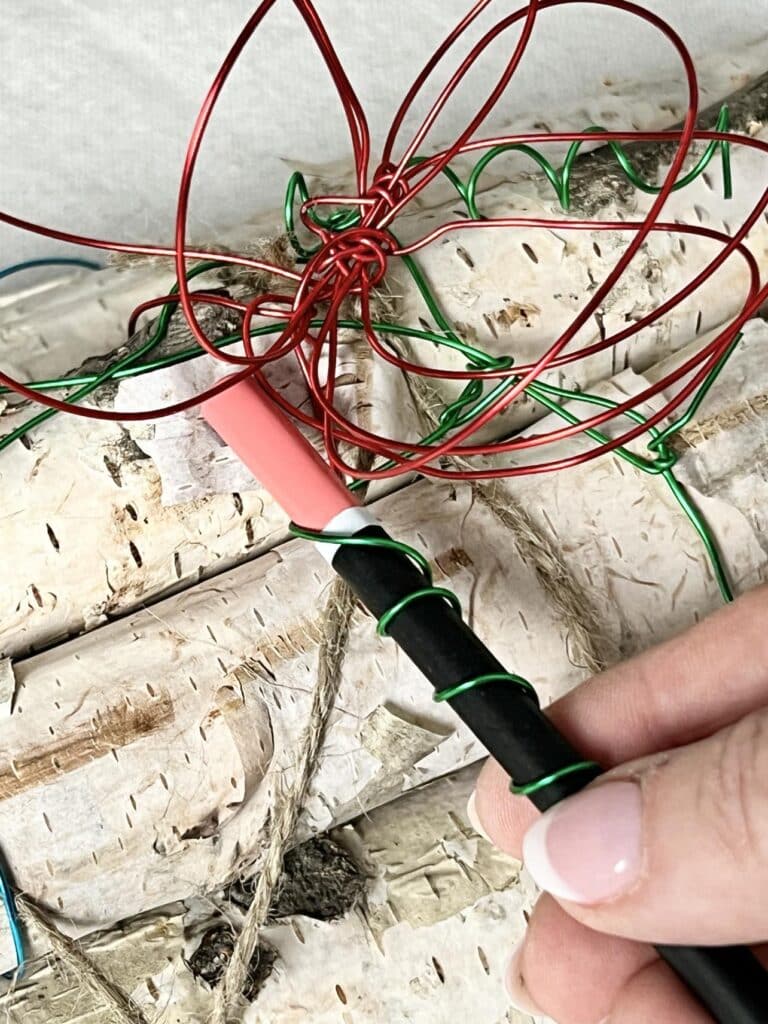 Creating a wire leaf by twisting wire around a pencil.