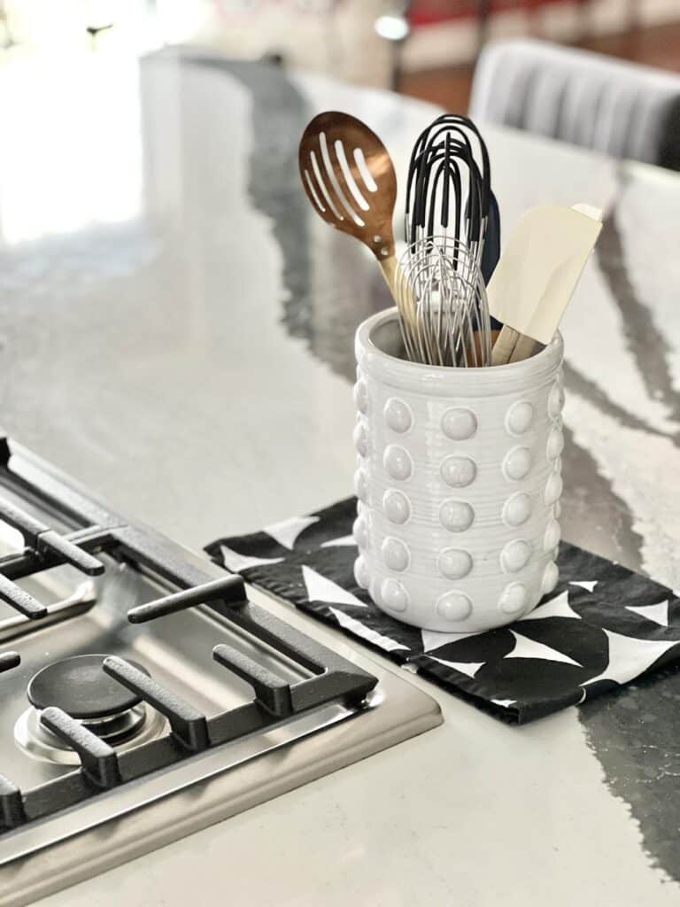 A utensil caddy is a great idea for how to decorate a kitchen island.