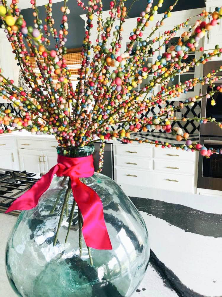 kitchen island centerpiece using multi-colored pip berries in a glass vase.