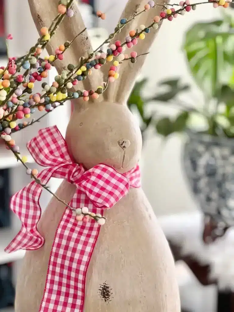 Concrete bunny with pink gingham ribbon.