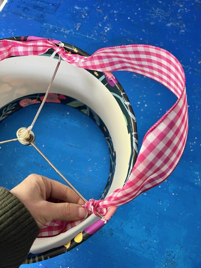 Tying a ribbon to the inside of the lampshade for hanging on a door.
