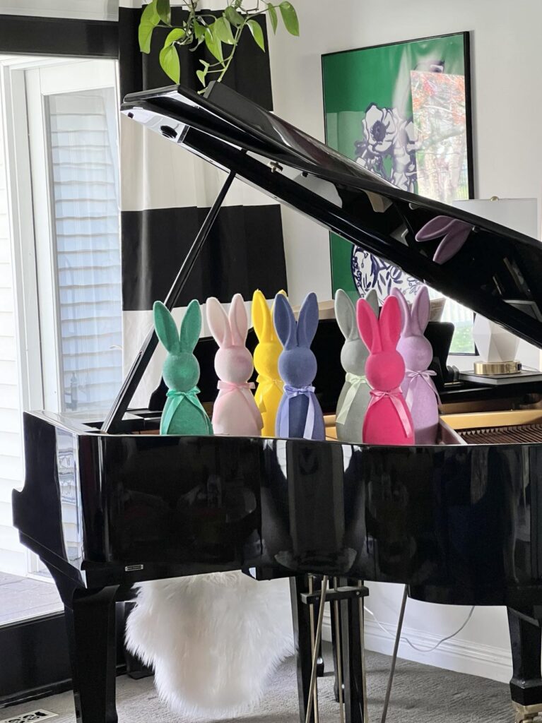 Colorful bunnies sitting in the piano.