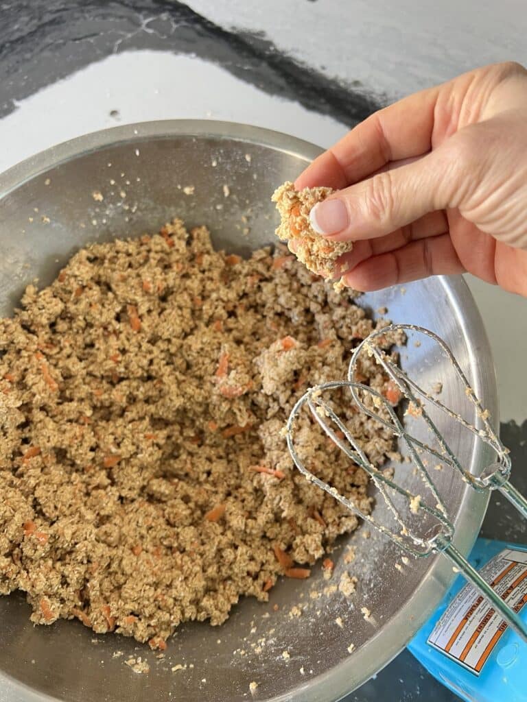 Pressing the dough between fingers to check for dryness.