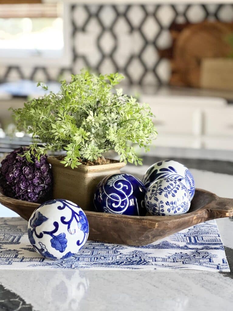 how to decorate a kitchen island - aa dough bowl holding ceramic spheres beside a plant.