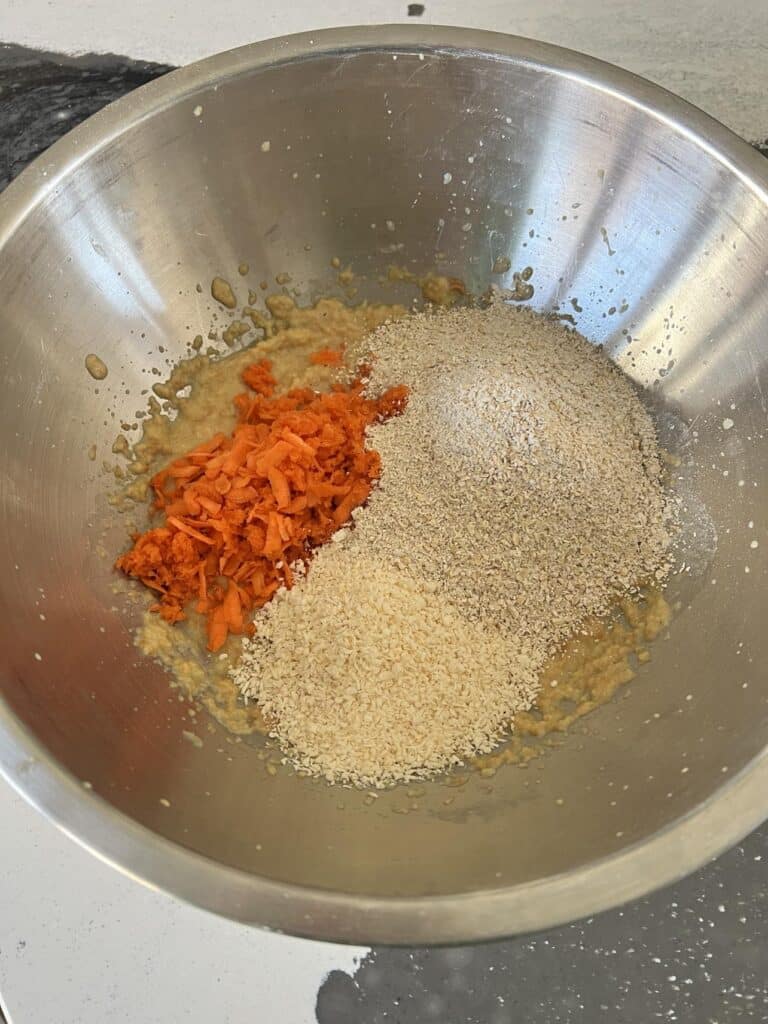 Mixing carrots, oats, and coconut.