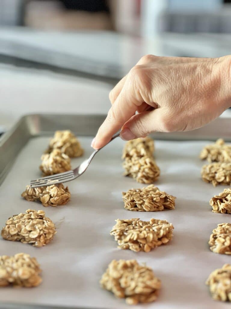 Pressing each dog treat with a fork.