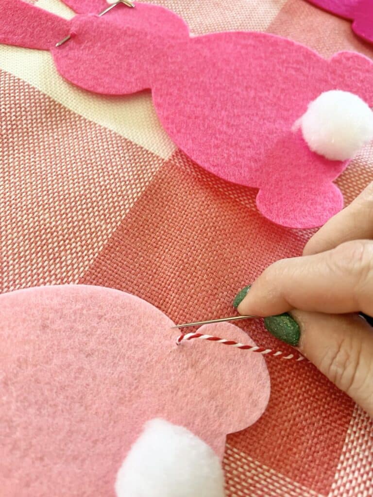 Hand stitching the felt funnies to the pillow cover.