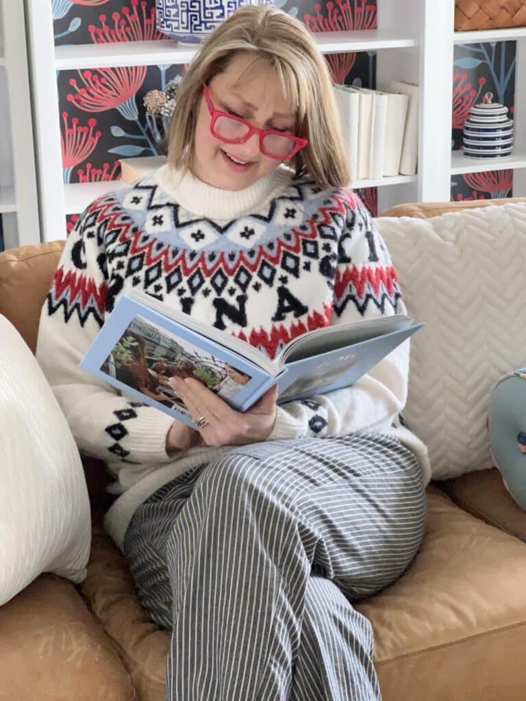 Missy wearing red reading glasses while reading a book. How to Wear Reading Glasses Stylishly
