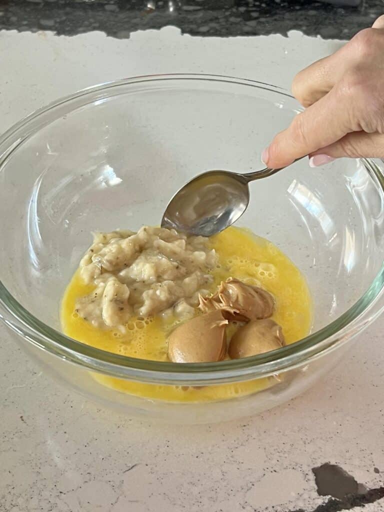 Mixing banana, egg, and peanut butter.