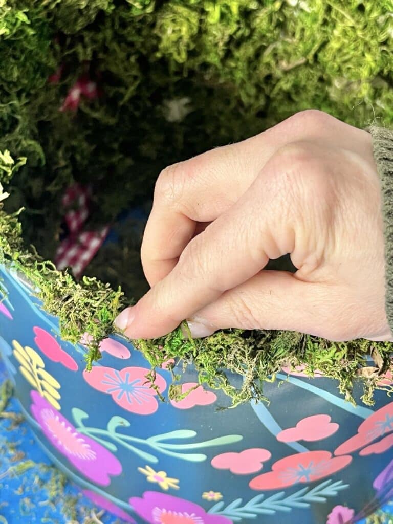 Pressing green moss onto the ege of the lampshade.