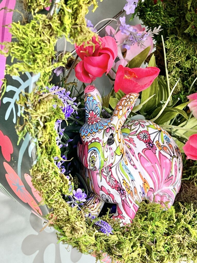 Faux floral stems and a bunny rabbit sitting inside the lampshade DIY Door Wreath.