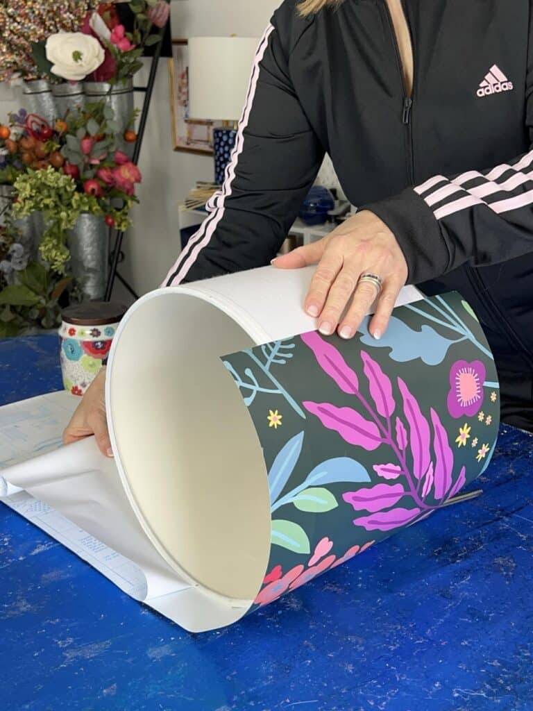 Rolling the lampshade on the peel-and-stick wallpaper.