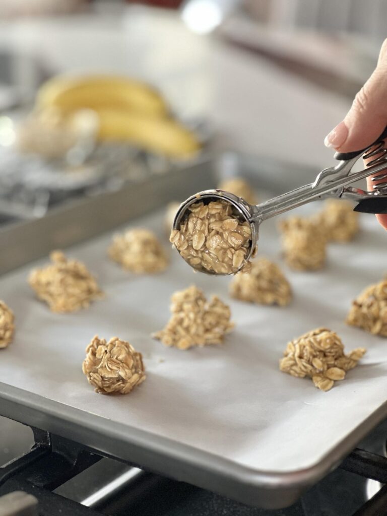 Scooping homemade oatmeal dog treat dough with an ice cream scoop.