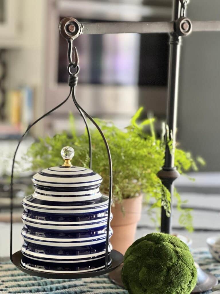 A kitchen scale holding a blue and white  porcelain jar on a kitchen island.