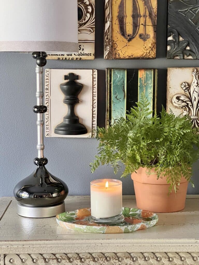 A decoupage glass tray holding a candle.