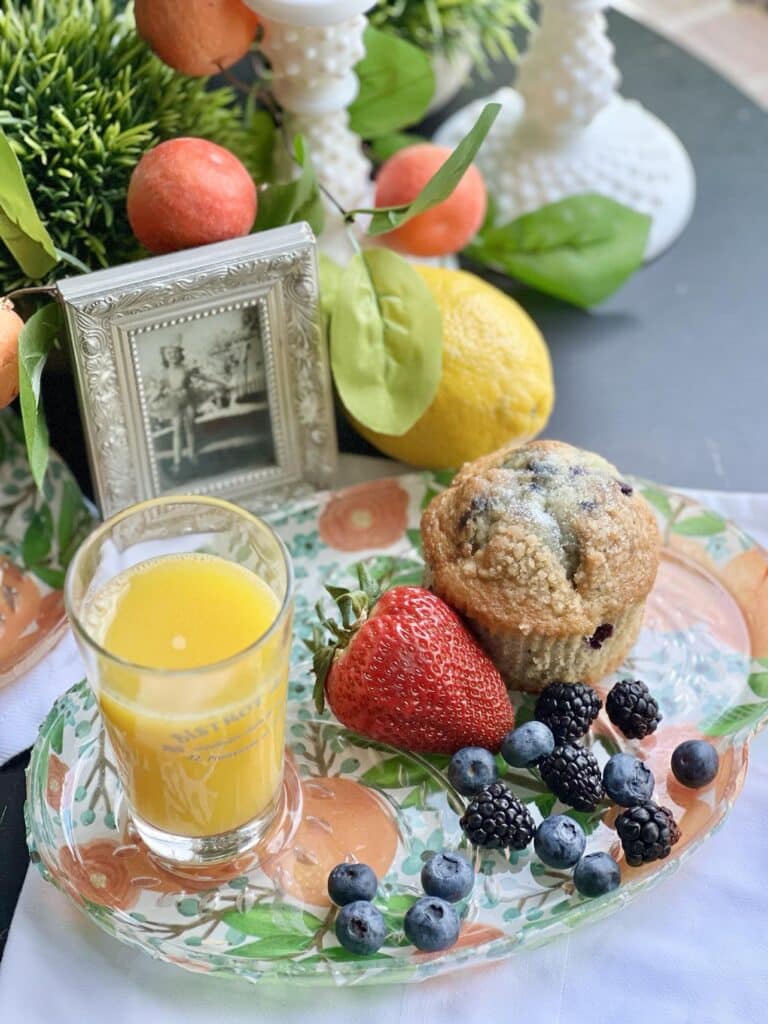 Orange juice and fresh fruit on a decoupage glass plate.