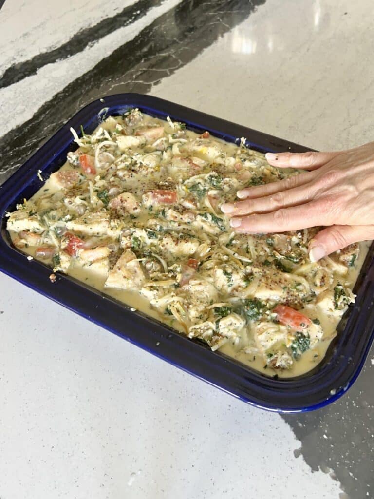 Pressing bagel pieces into egg mixture with fingers.