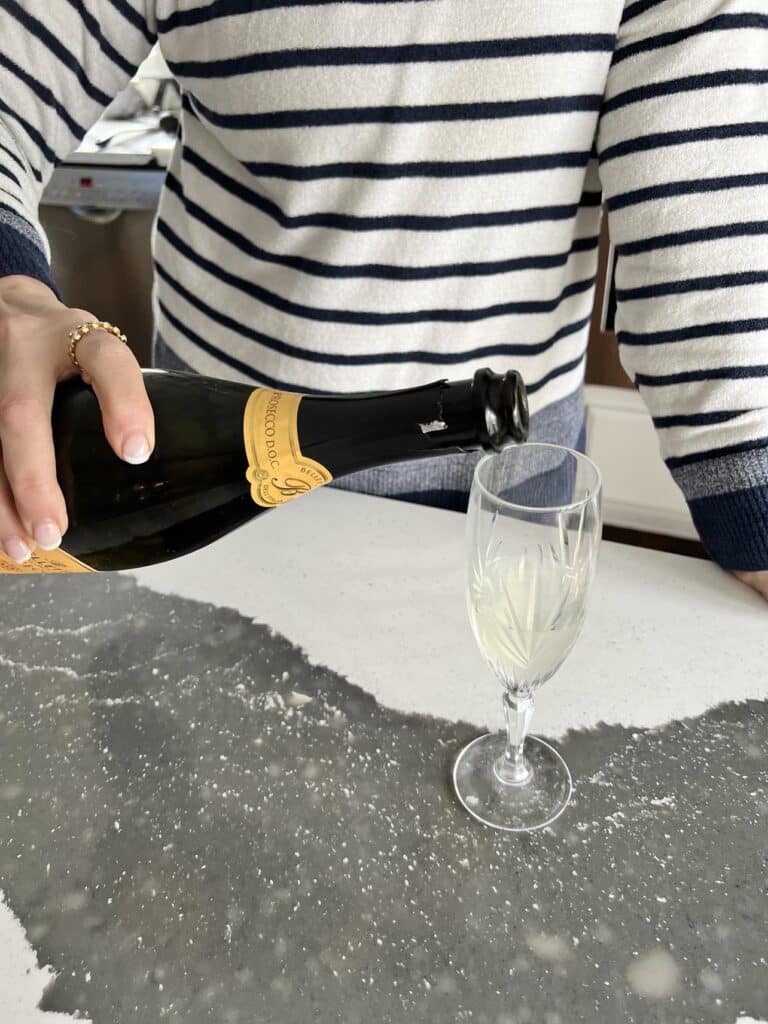 Pouring prosecco into a champagne flute.