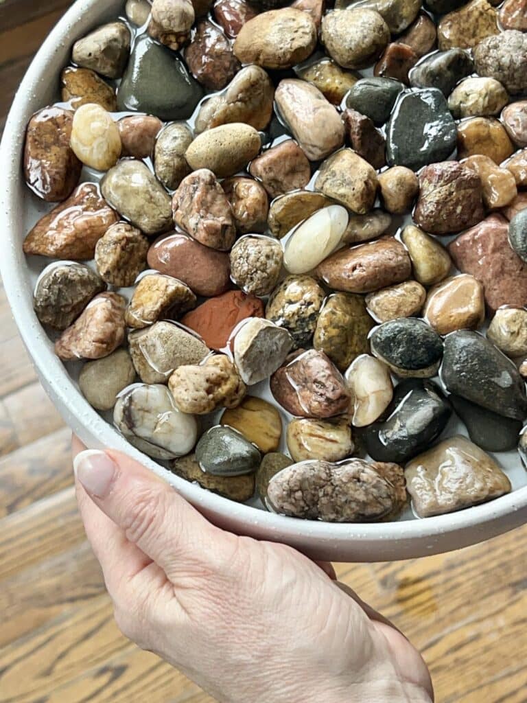 Rocks sitting in water for a pebble tray for plants.