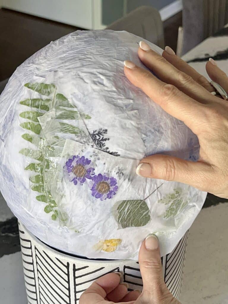 Gluing tissue paper on top of pressed flowers on balloon - Sonata Home Design