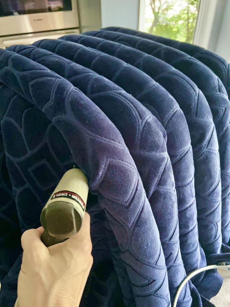 Stapling pool noodles to create channel tufting in a coffee table ottoman diy.
