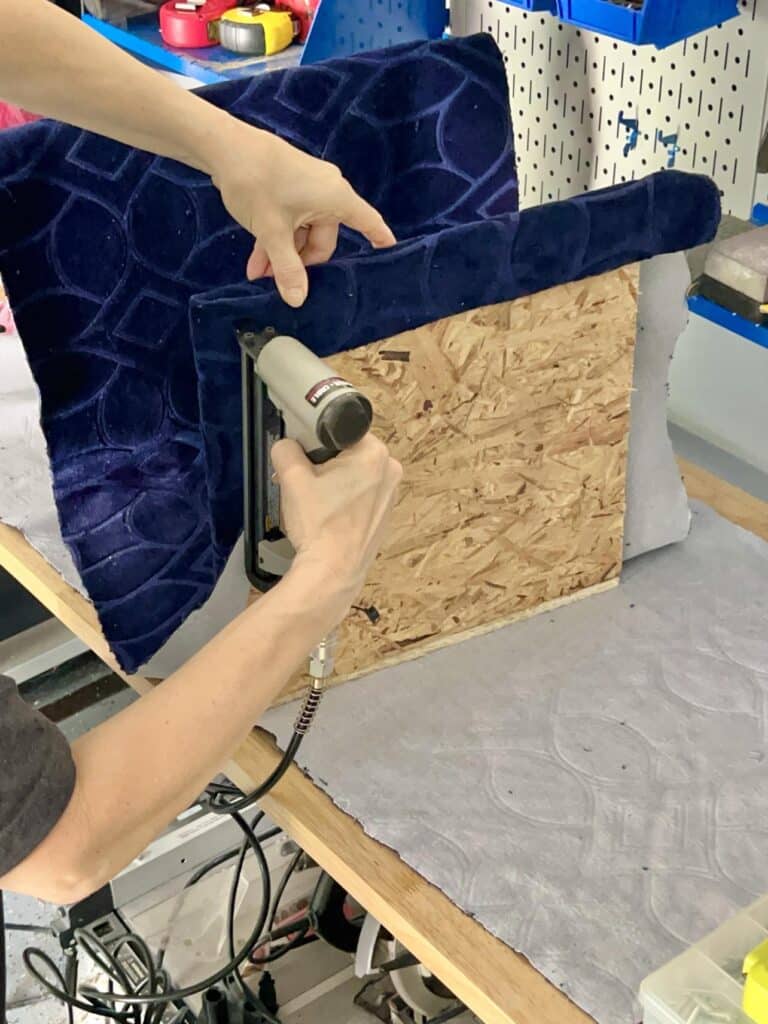 Stapling fabric on the ottoman frame.