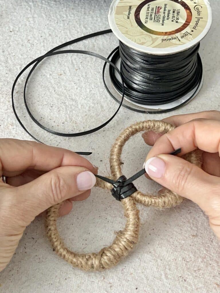 Tying together two curtain rings for a DIY lazy Susan project.