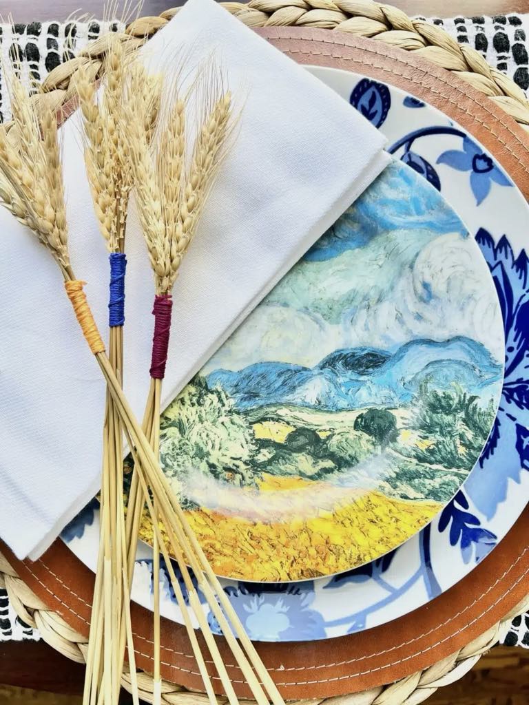 wheat bundle decor placed on top of Thanksgiving dinnerware.