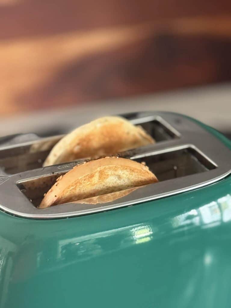 Toasted bagels slices in a green toaster.
