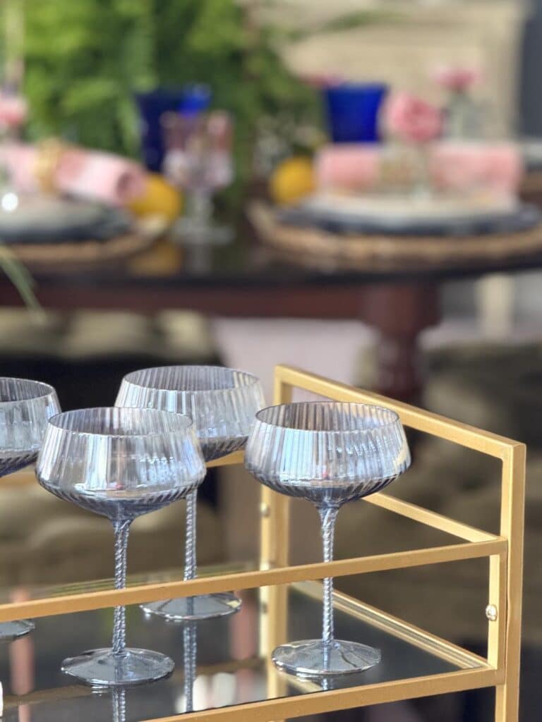 Coup glasses on a gold bar cart.