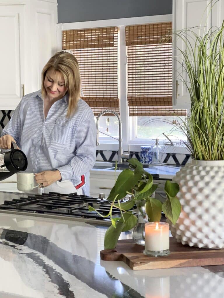 Woman pouring a cup of coffee in the kitchen.