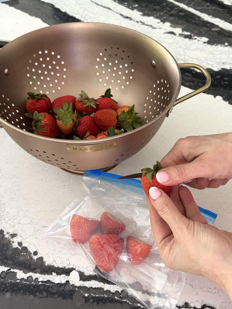 cutting off the tops of strawberries.