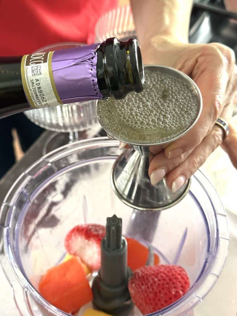 Pouring prosecco in a measuring cup.