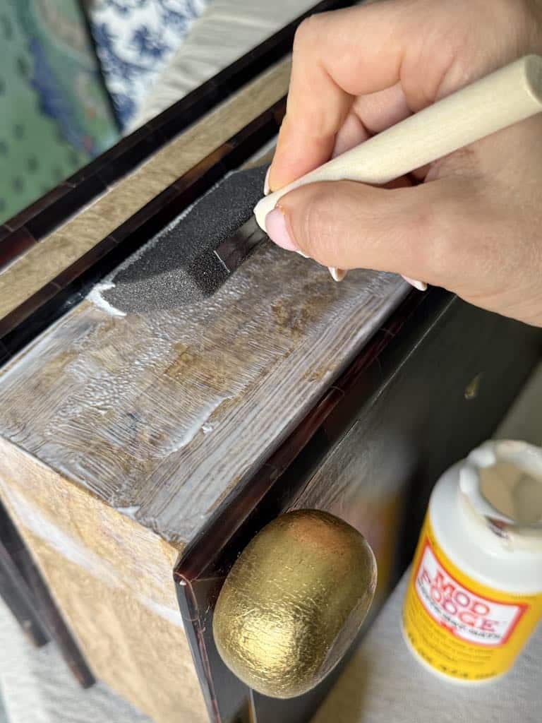 Brushing Mod Podge on a thrifted box.