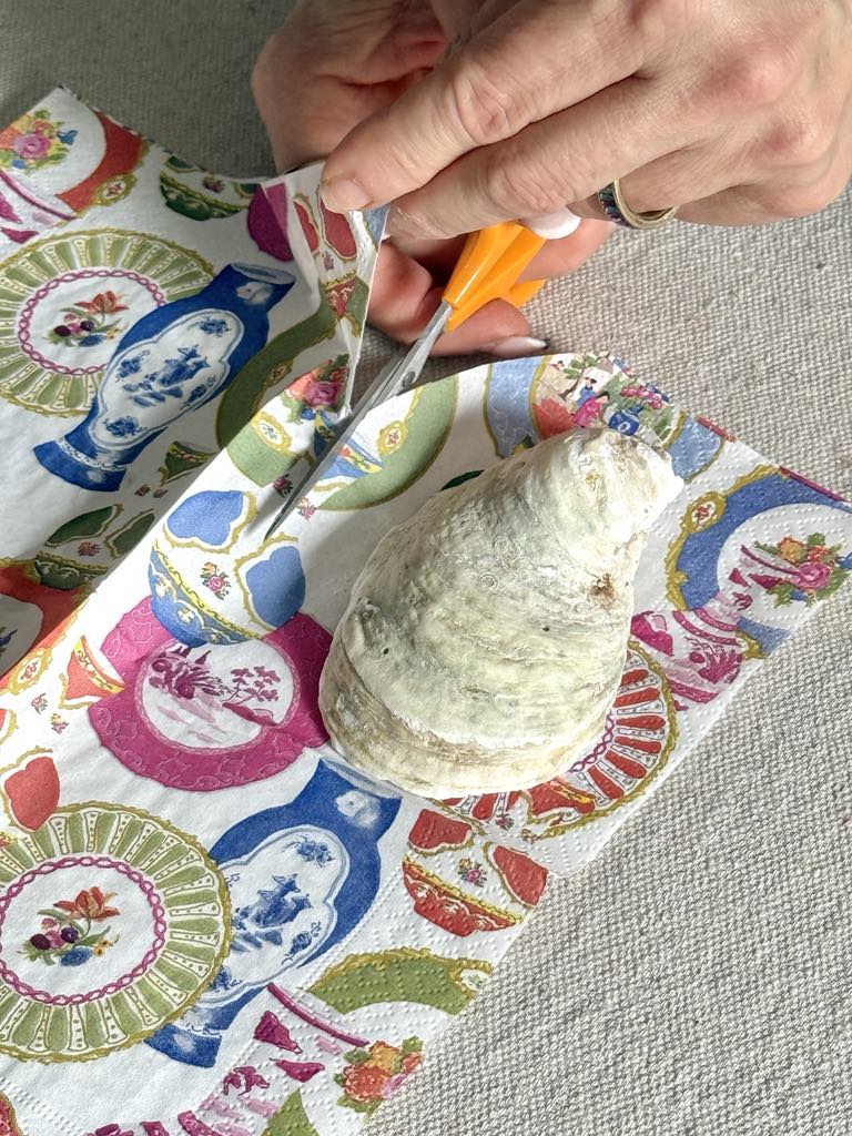 Cutting a paper napkin around an oyster shell.