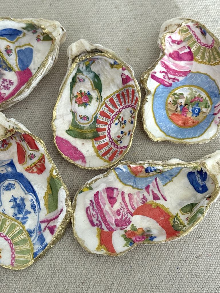 Five gold rimmed decoupage shells.