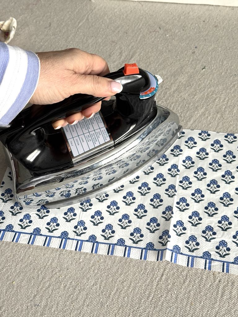 Ironing a blue and white paper napkin.