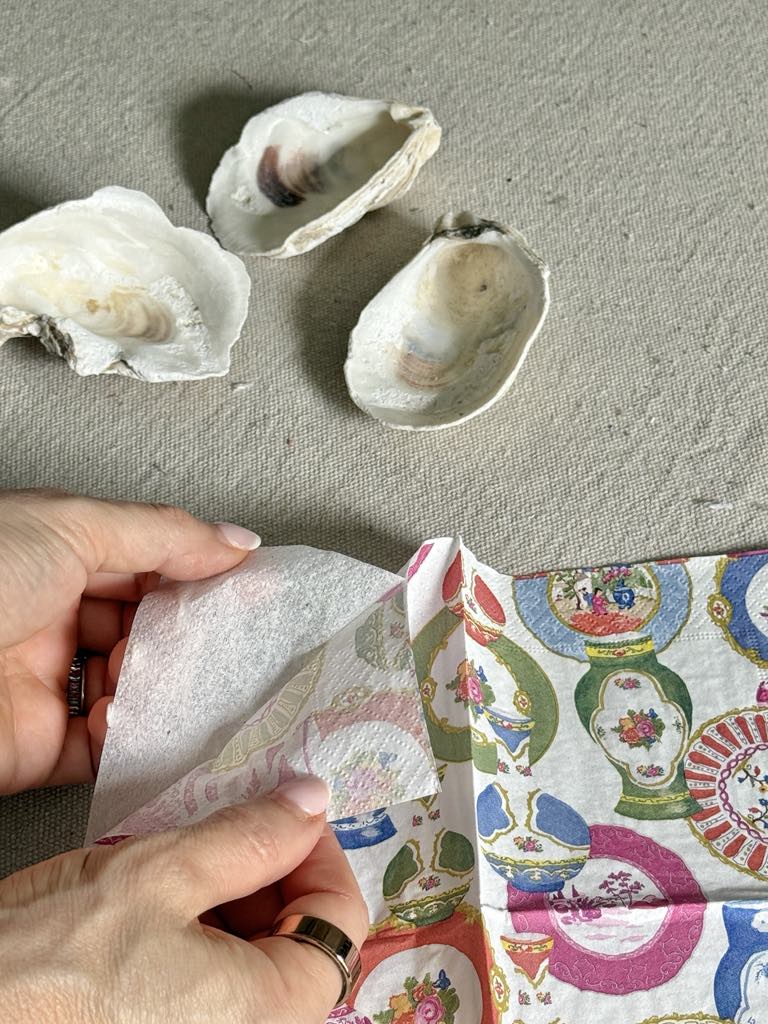 Tearing away the top layer of a paper napkin.