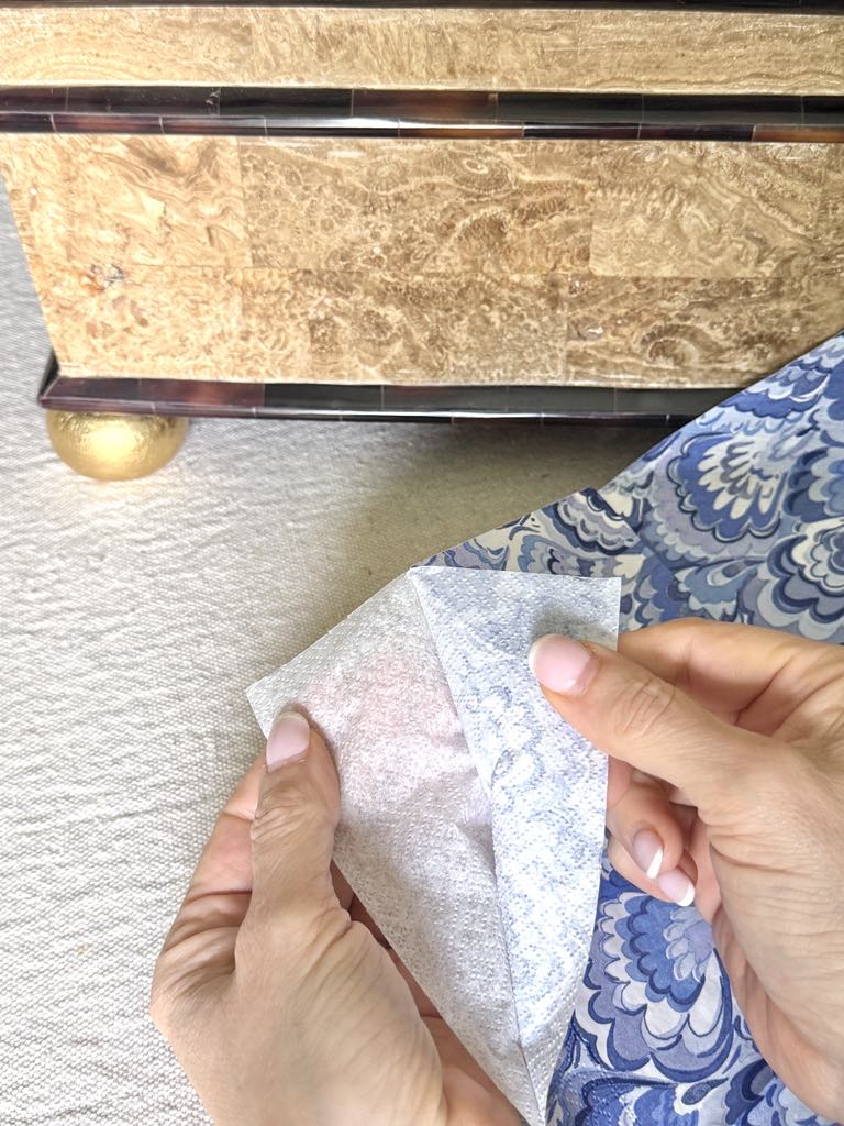 Separating the layers of a paper napkin.