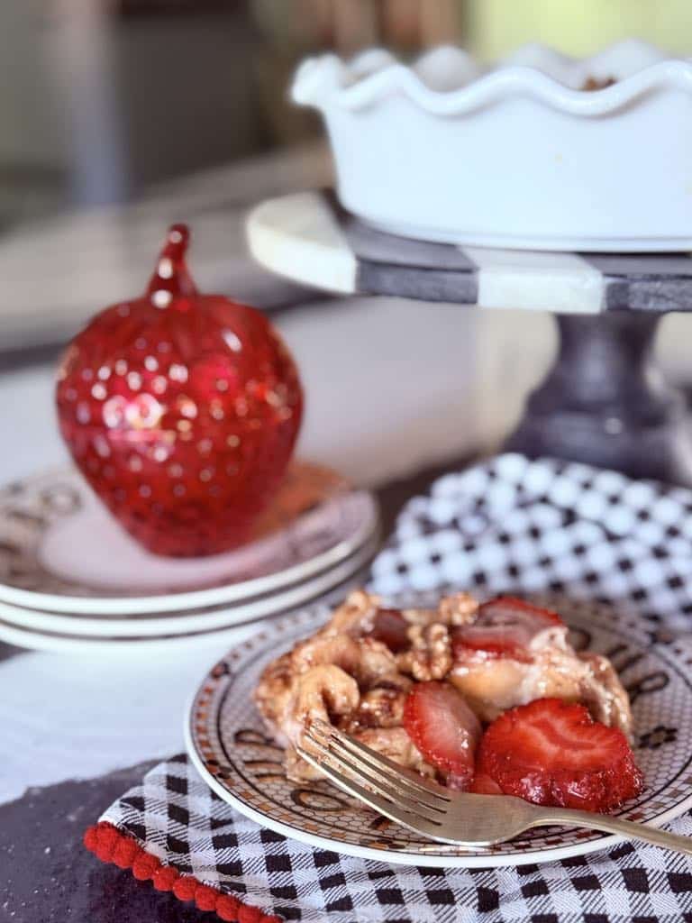 Plated Strawberry Cinnamon Roll Casserole on a plate with a fork.
