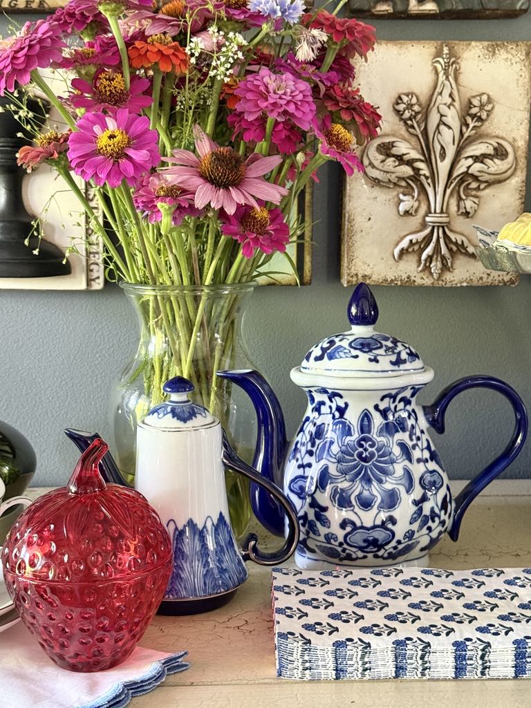 Two blue and white teapots styled as part of a tea party tablescape.