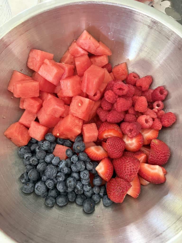 Watermelon, blueberries, strawberries, and raspberries in a fruit bowl.