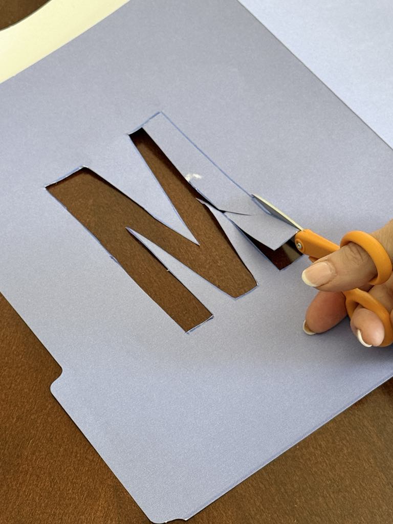 Cutting out the letter "M".
