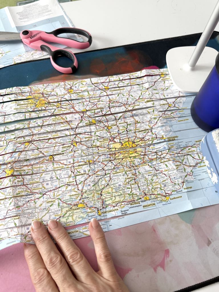 Horizontally cut strips of a map lines up to create a DIY travel journal cover.