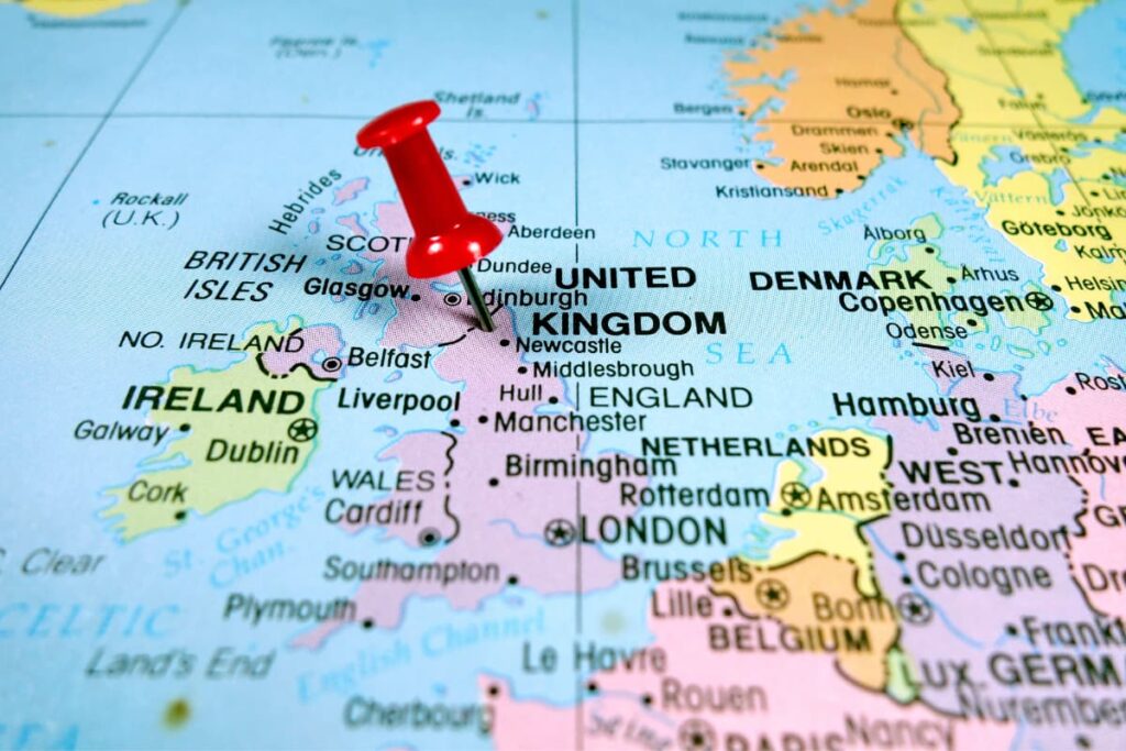 Map of United Kingdom with red push pin stuck in center.